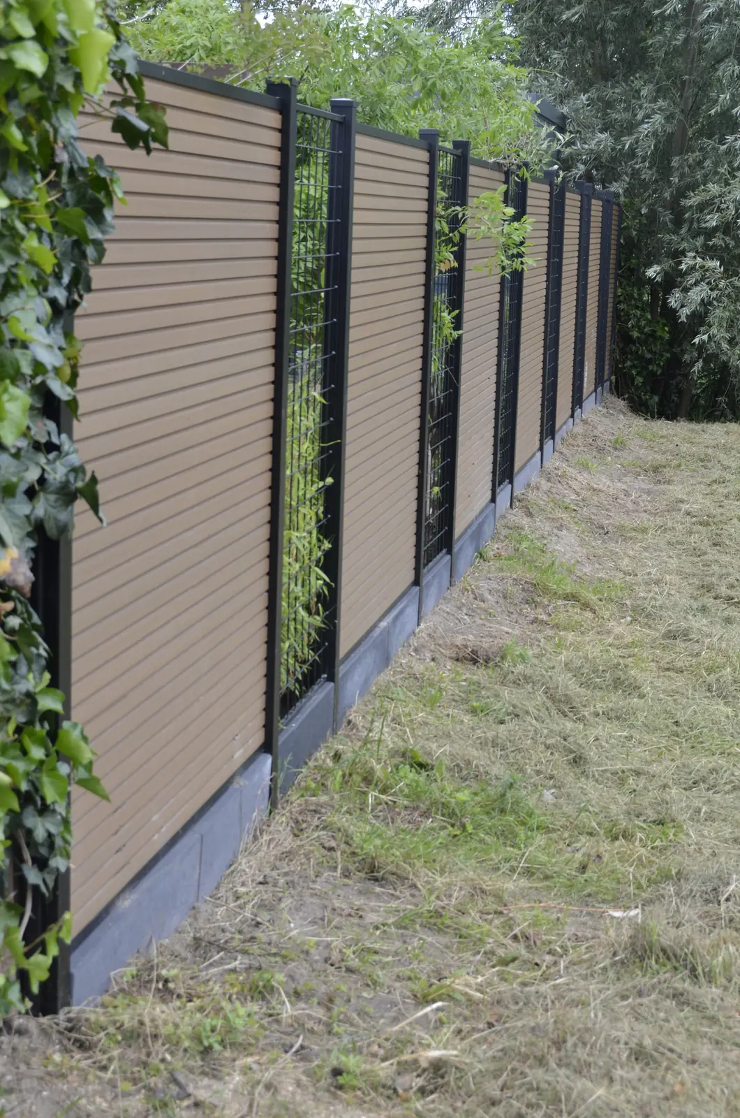 Afwisseling van dichte panelen en open gaas in de schutting