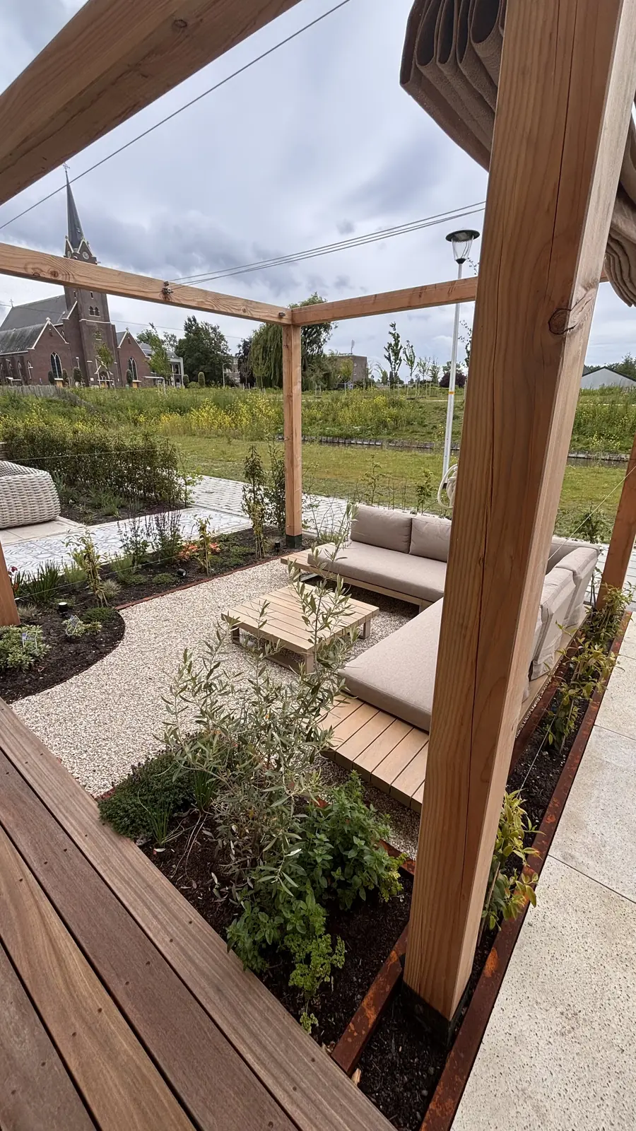 Douglas pergola langs de gevel met daaronder de zithoek