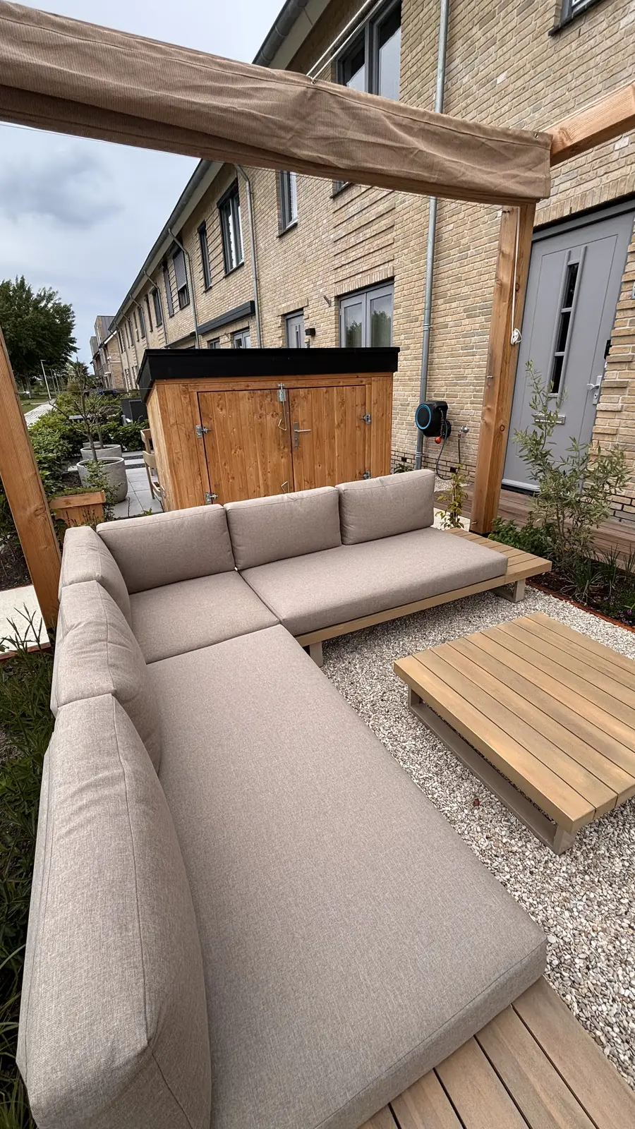 De voorzijde van de woning met pergola en nieuwe beplanting