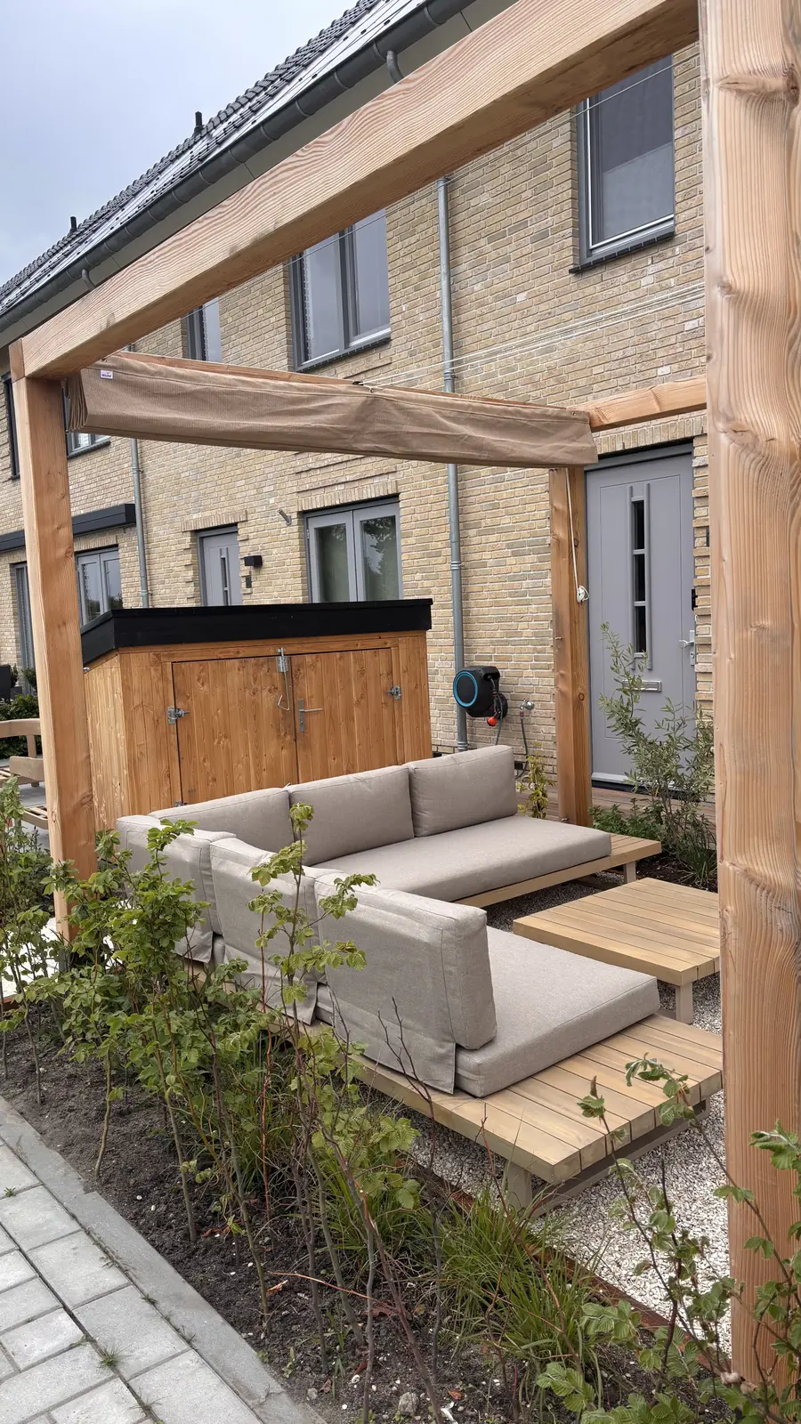 De pergola met loungeset, met de kerk op de achtergrond