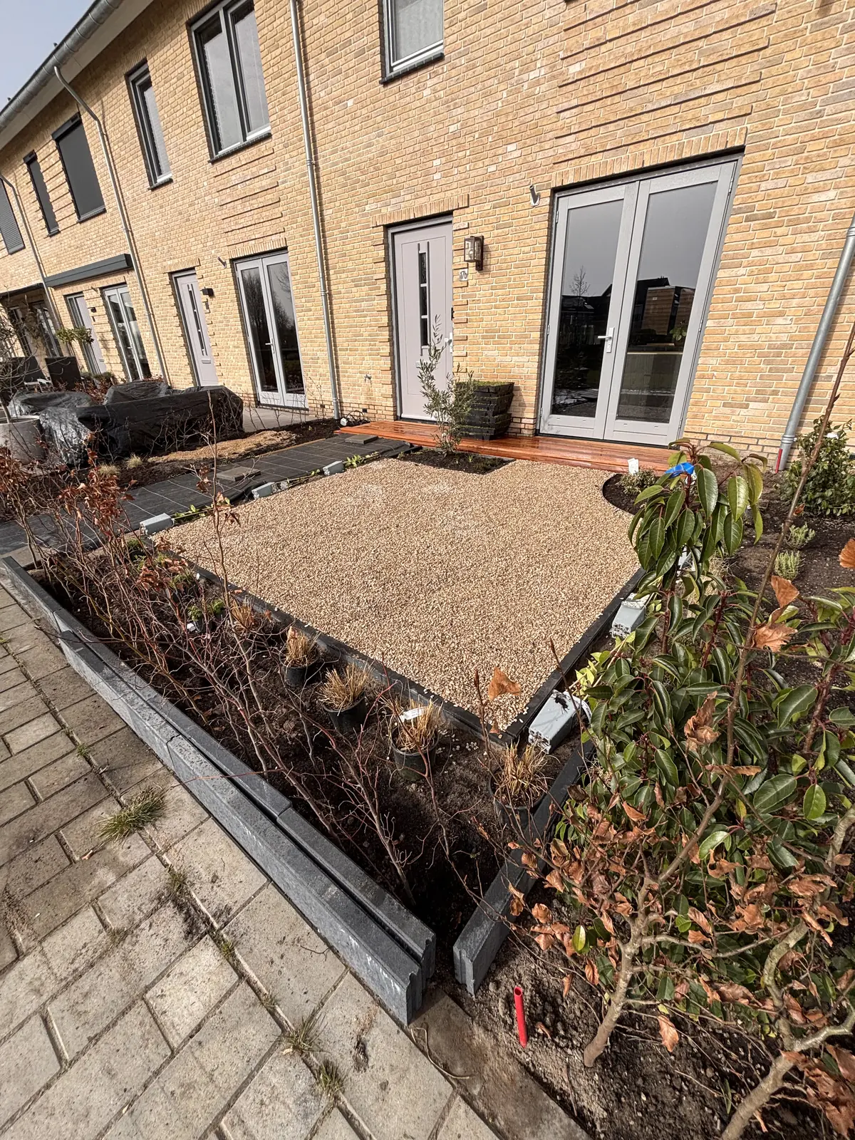Zandbed met kantopsluiting langs de gevel