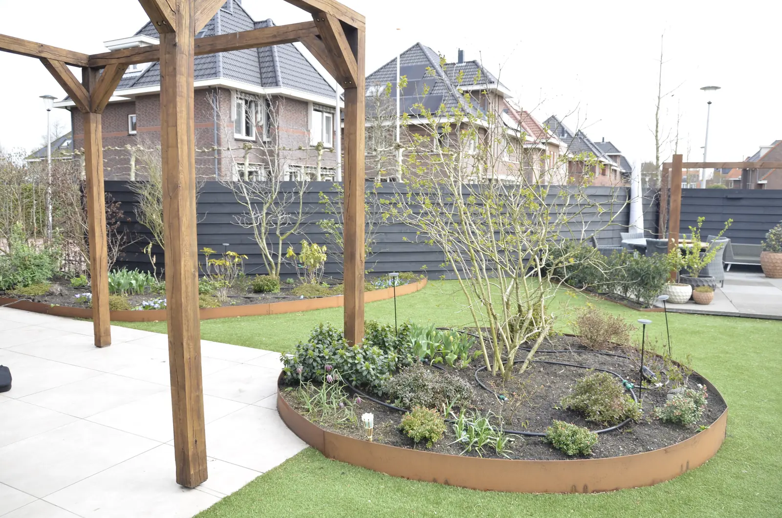Doorkijk onder de douglas overkapping over het gazon naar het terras