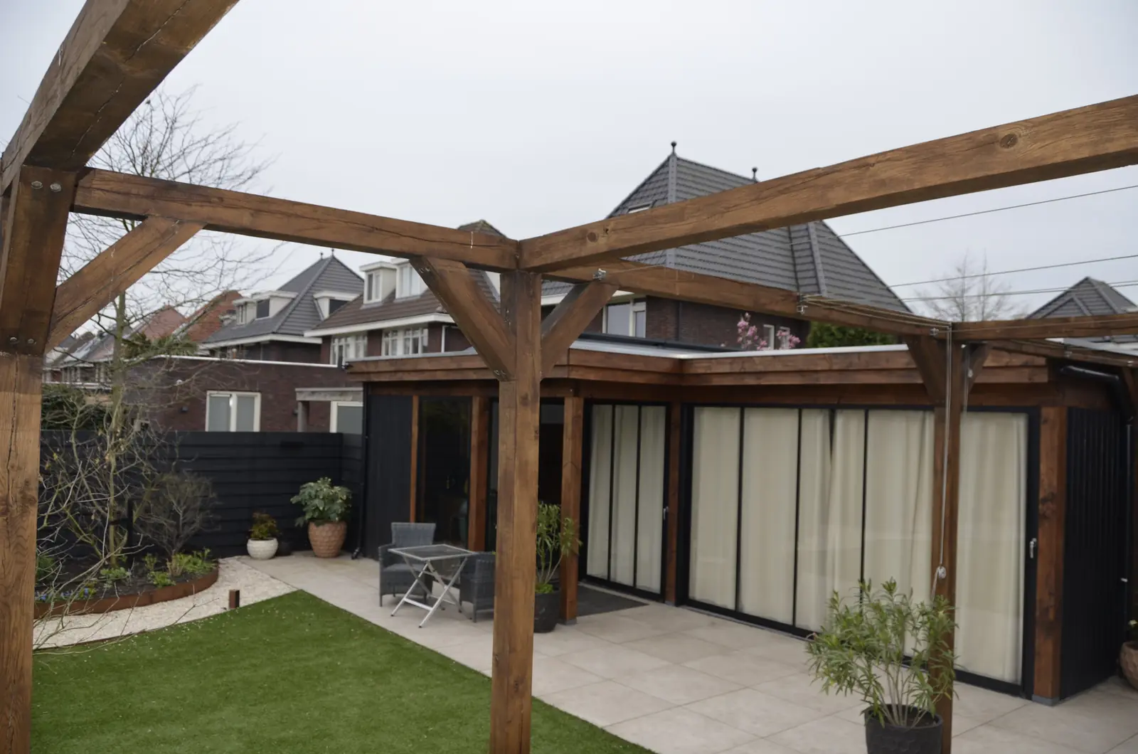 Onder de douglas overkapping door naar het gazon en de schuifpui