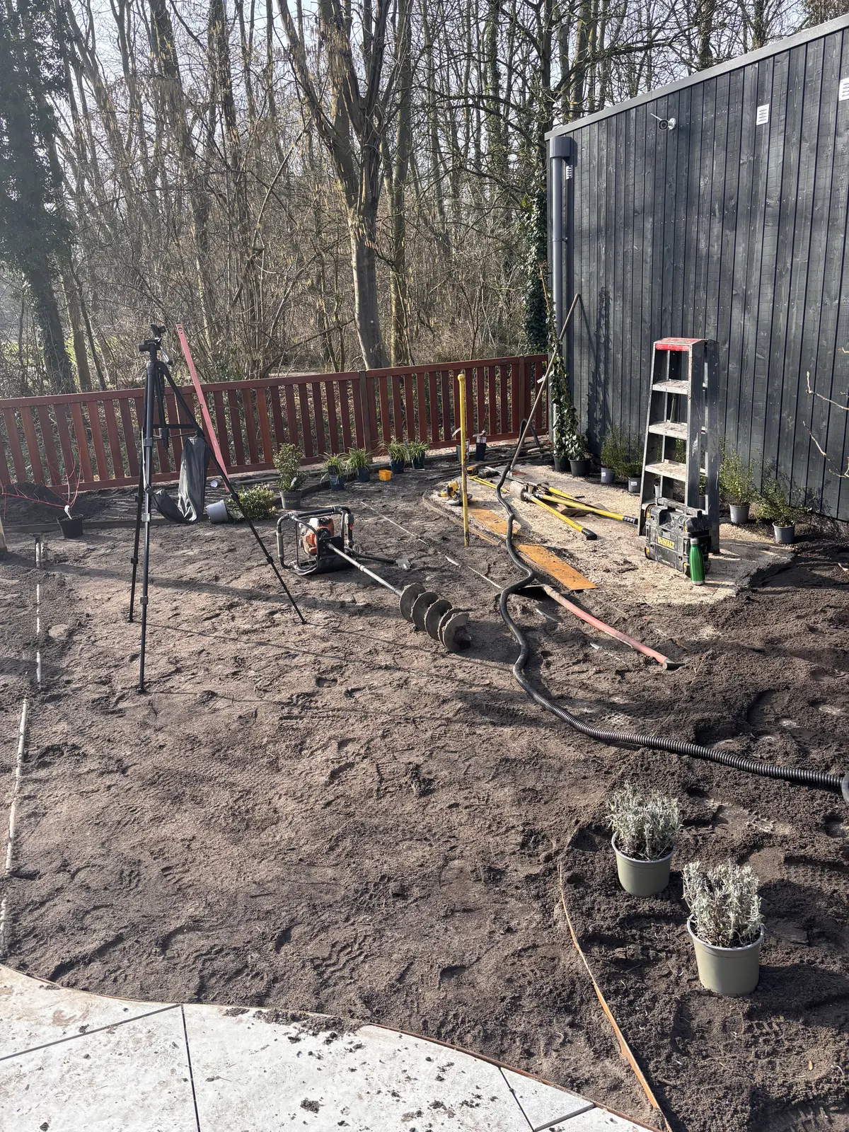 Graszoden klaar om te leggen naast een houten paal