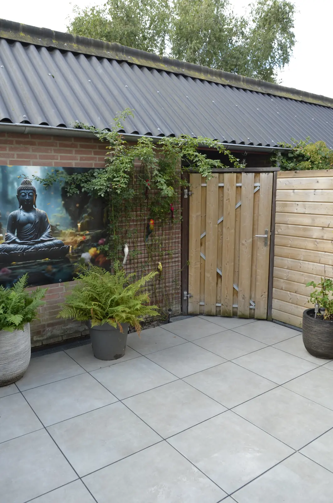 Hoek van de stadstuin met tuinposter en beplanting