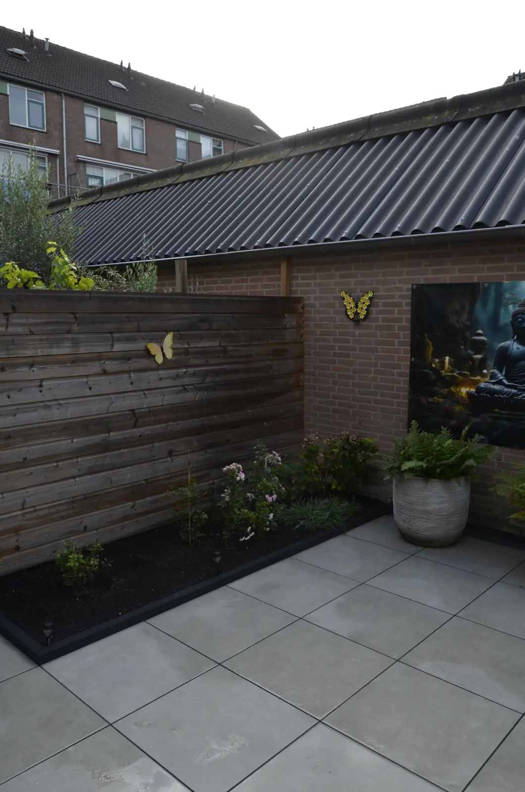 De tuin gezien vanaf het huis, met de buurpanden erachter