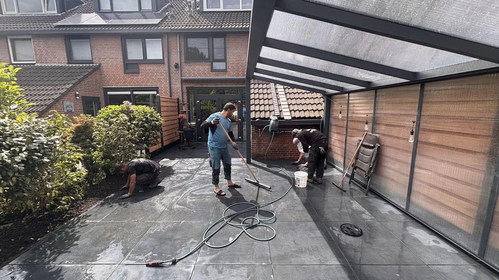 Overzicht van het terras tijdens het werk, met de veranda erboven