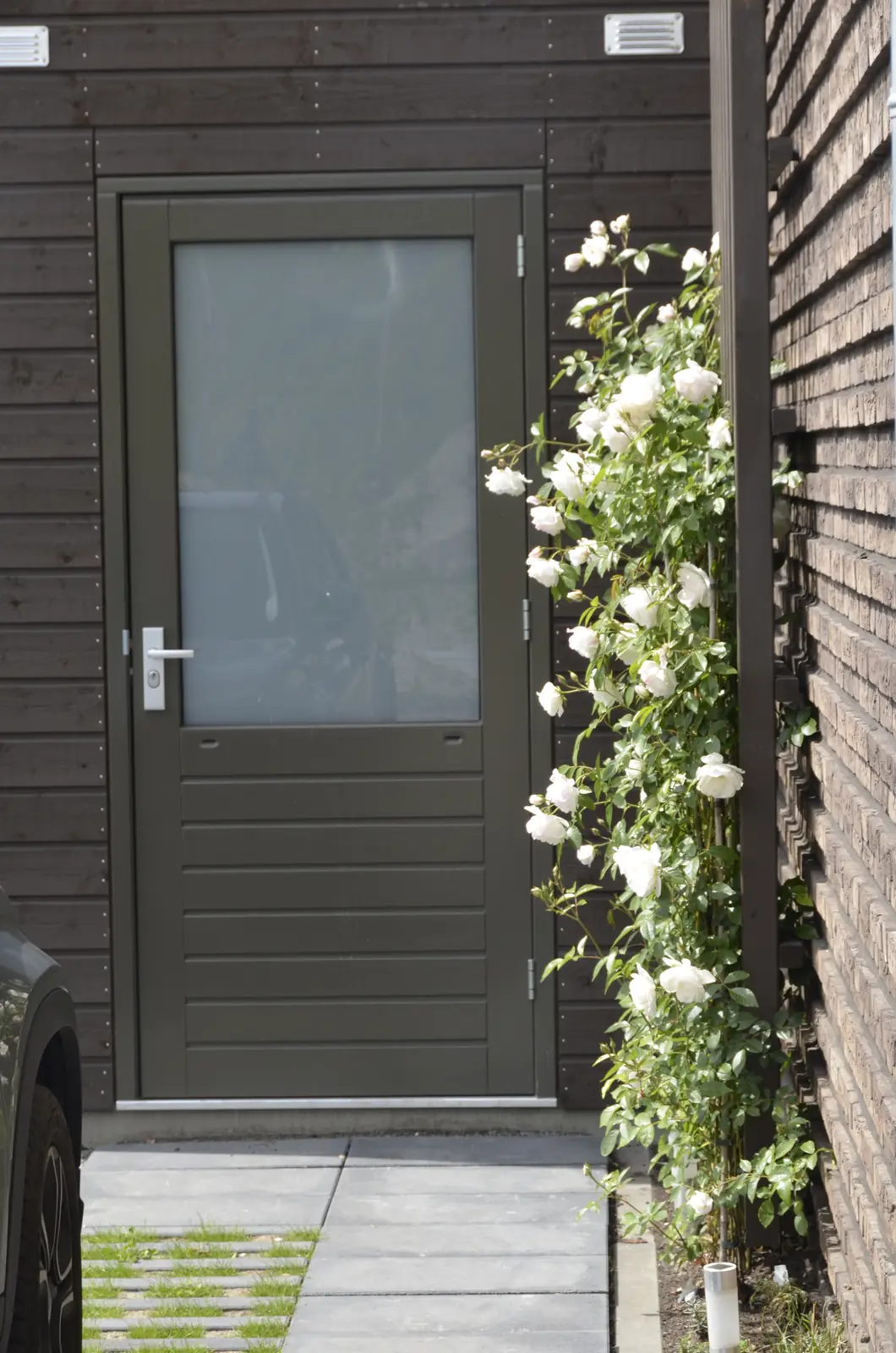 Berging met containerplek achter een houten wand, aan het water